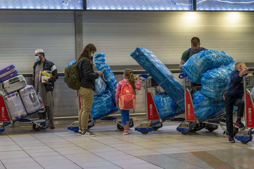 FILE - People line up to get on an overseas flight at OR Tambo International Airport in Johannesburg, South Africa, Nov. 26, 2021. As the world grapples with the emergence of the new highly transmissible variant of COVID-19, worried scientists in South Africa — where omicron was first identified — are scrambling to combat its lightning spread across the country. (AP Photo/Jerome Delay, File)